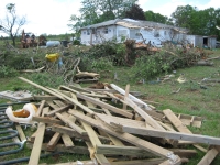 Another view of damage around the manufactured homes. This house in the distance suffered some damage and notice the tree that was snapped. ~966 kb